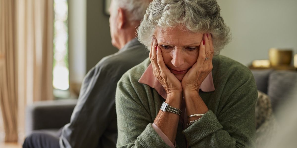 Upset senior woman, man sitting with back to her