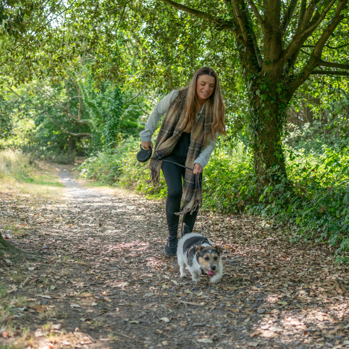 woman walking a little terrier dog