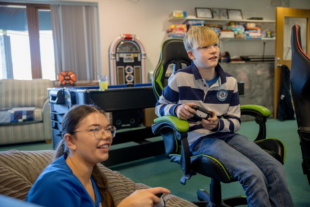 Boy gaming with carer