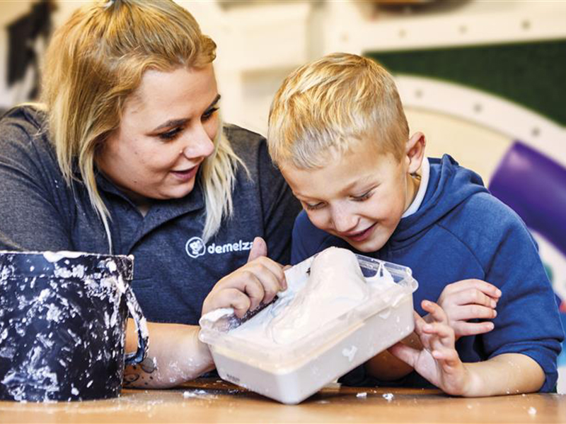 Boy crafting with care team member