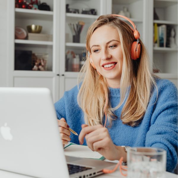 Woman wearing headphones looking at a laptop