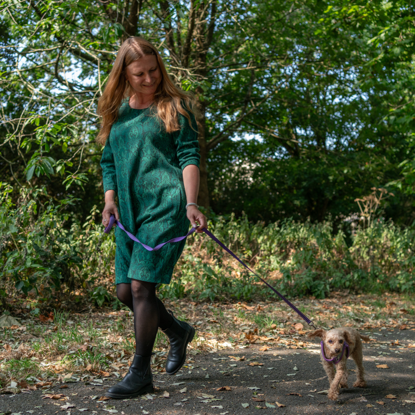woman walking a tiny poodle
