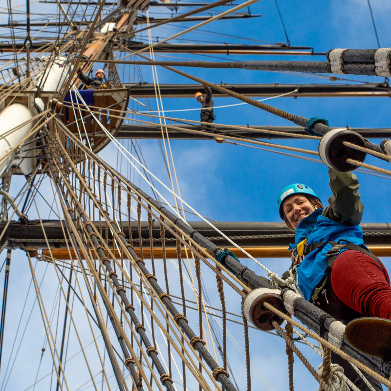 A photo looking up into the Cutty Sark's rigging with two people looking down and smiling